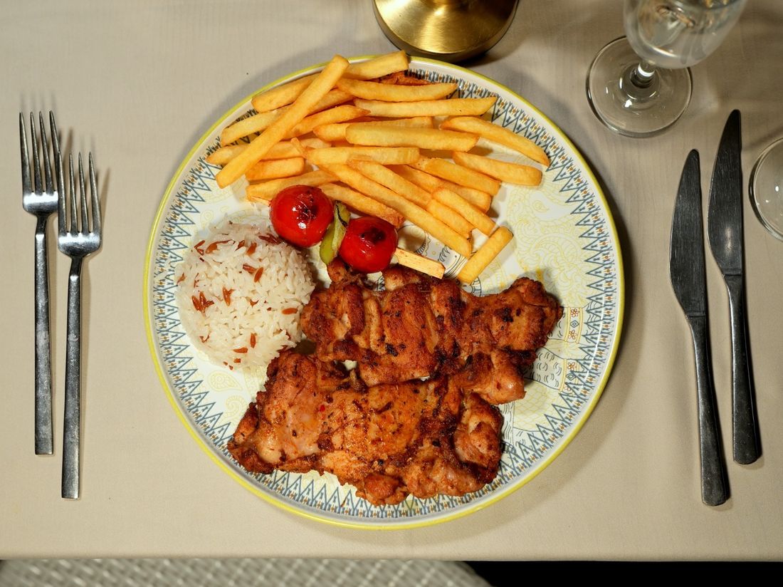 Grilled chicken steak plated with rice and vegetables